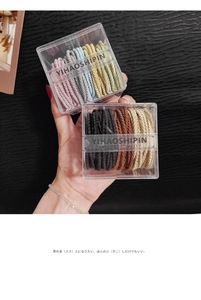 Detail of high-elasticity braided hair ties in transparent storage boxes with macro texture