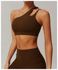 Detail of one-shoulder cut-out yoga bra and high waist leggings in chocolate brown
