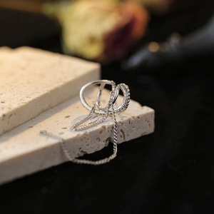 Silver ear cuff with double layered chains and tassel fringe on a stone tray