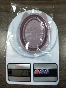 Weight measurement of purple silicone makeup brush cleaning mat in protective plastic bag