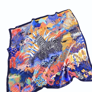 Detailed view of satin silk scarf featuring vibrant zebra and jungle botanical patterns