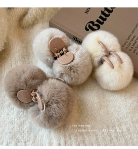 Detailed view of plush faux fur hair claws in coffee, grey, and cream colors