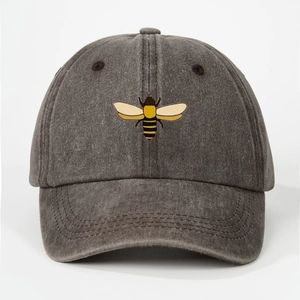 Close-up of printed bee logo on dark gray washed cotton baseball cap with visible stitching
