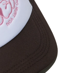 Nahaufnahme der Trucker-Mütze mit braunen Nähten und pinkfarbenem Stickereidetail