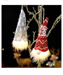 Detail of hanging Christmas gnomes with glowing LED lights and warm holiday knit patterns
