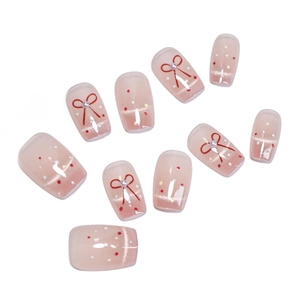 Faux ongles œil de chat rose avec nœuds rouges et petites perles sur fond blanc épuré