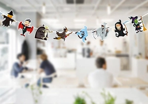 Close-up of Halloween paper banner featuring cartoon ghosts, witches and pumpkin characters