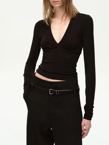Dettaglio del top in maglia nera con scollo a V e design aderente su modella