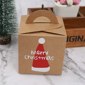 Brown kraft paper Christmas gift box with red Santa hat print on marble surface