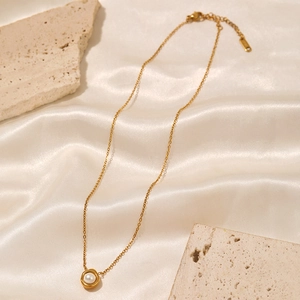 French style pearl necklace with gold chain and pendant on white silk background