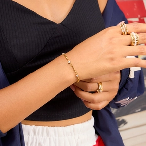 Close-up of 18K gold-plated stainless steel bracelet and rings set with white zircon