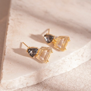 Macro shot of geometric earrings featuring triangle smoke grey and champagne crystals