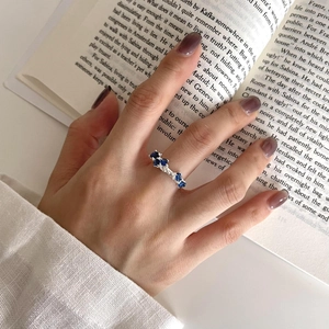 Detail shot of irregular S925 silver ring with blue sapphire zircon stones on hand