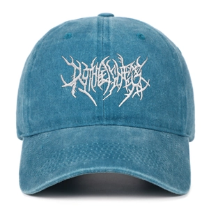 Detailed macro view of white gothic embroidery on washed blue cotton baseball cap