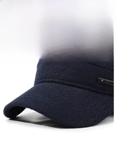 Detailed view of the structured brim and fashion metal plate on a navy winter cap
