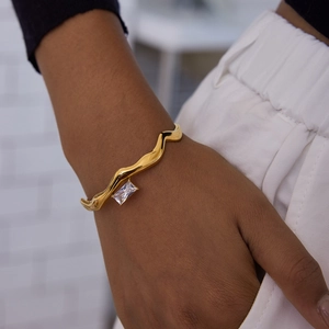 Detail of 18K gold-plated stainless steel wave cuff with a rectangular white zircon