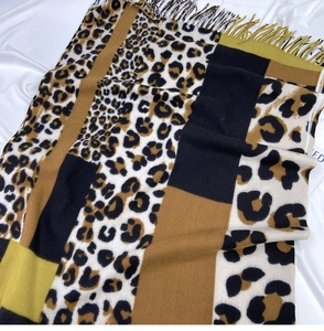 Detail of color-block leopard print scarf with soft fringe edges and patchwork design