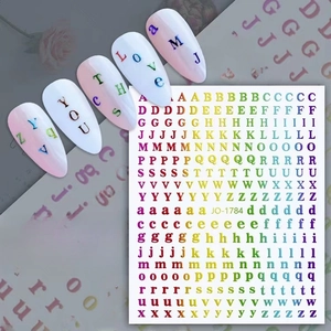 Detail showing JO-1784 metallic gold alphabet nail stickers applied on manicured nails
