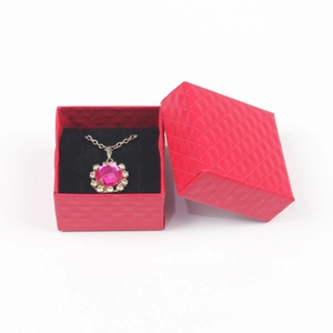 Pink gemstone pendant necklace with white diamonds in a red textured jewelry gift box