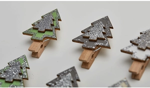 Close-up of green and grey wooden Christmas tree clips with festive glitter texture