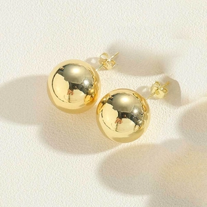 Close-up of high-polish 14K gold-plated ball stud earrings with butterfly backings