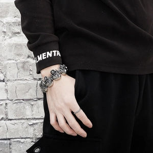 Detail shot of men's vintage skull bracelet in retro punk style with engraved metal links