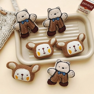 Detail of cute brown plush bear and rabbit brooches for DIY apparel decoration
