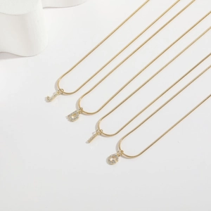 14k gold plated snake chain necklace with zircon initial letters J D L G on white background