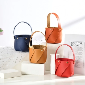 Mini leather favor baskets in blue, camel, orange and red with gold rivet accents
