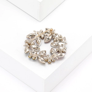 Detail view of crystal olive branch wreath brooch showing safety pin clasp and silver metal back
