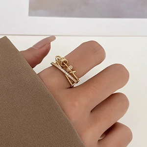 Close-up of a golden crown-shaped anxiety ring with zircons worn on a finger