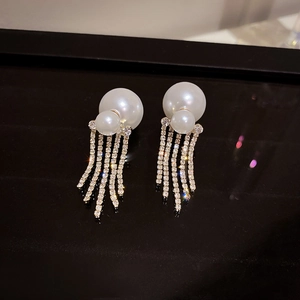 Macro shot of silver pearl tassel earrings with shimmering rhinestone fringe detail