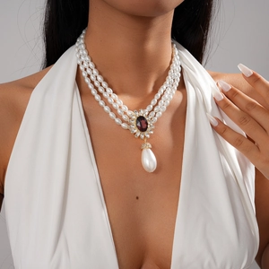 Détail d'un collier de perles vintage à trois rangs avec pendentif goutte en améthyste