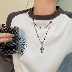 Gros plan d'un collier argenté à double épaisseur avec pendentif croix sur mannequin