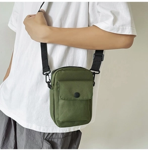 Detail of army green canvas mini crossbody bag with black buckle on model