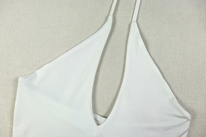 Detail of white deep V-neck halter dress featuring smooth high-elasticity fabric