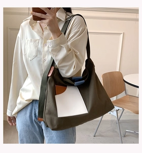 Detailed shot of an olive green canvas tote bag with white pocket and brown leather trim