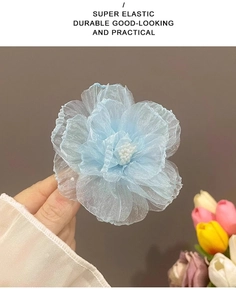 Détail d'une pince à cheveux fleur en organza bleu aux pétales translucides superposés
