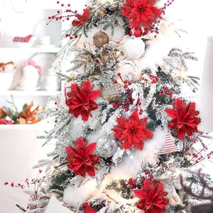Macro shot of 14cm red glitter artificial flowers decorating a snowy Christmas tree