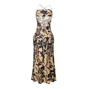 Detail of cross-back tie straps on a beige maxi dress with black tropical leaf prints