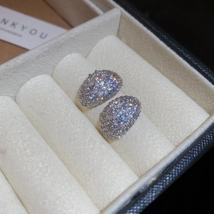 Macro shot of silver crescent earrings with sparkling zircon inlay in a white jewelry box