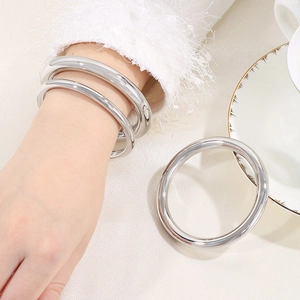 Macro view of high-polished stainless steel tubular bangles with smooth metallic finish