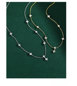 Detail of S925 silver clover necklaces in gold and silver finish with zircon stones