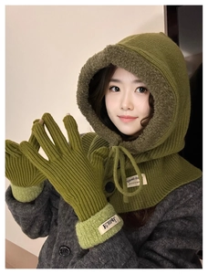 Close-up of olive green knitted balaclava hood and matching gloves with plush cuffs