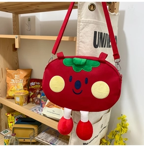 Detail of red strawberry cartoon canvas bag with cute legs hanging in a cozy room