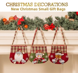 Three festive Christmas gift bags with Santa, snowman and reindeer on a white fireplace