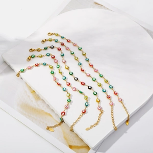 Detail of colorful Evil Eye charm bracelets in gold stainless steel on a white display