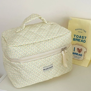 Quilted cream polka dot cosmetic bag with sturdy handle and dual zipper for travel