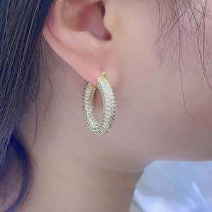 Detail of 18K gold plated hoop earrings with three rows of micro-paved white zircons
