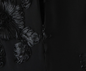 Detail of hidden side zipper and elegant 3D satin flower embroidery on black dress